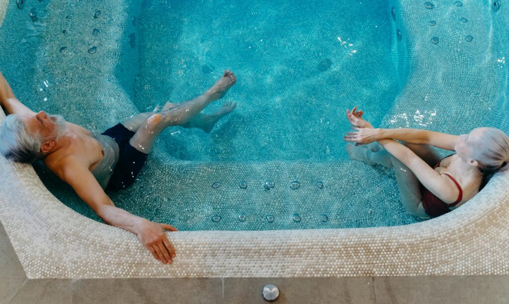 Elderly couple enjoying leisure time in a swimming pool. Overhead view.
